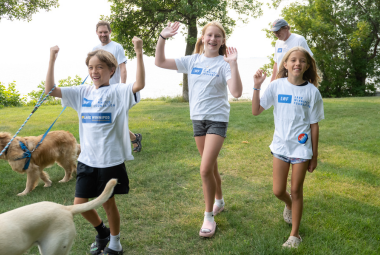 Kids celebrating as they walk by the lake.